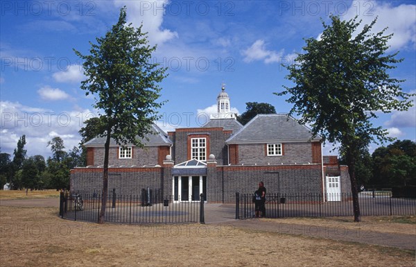 ENGLAND, London, Kensington Gardens.  The Serpentine Gallery exterior with visitors standing beside railings at the entrance.