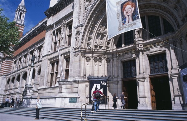 20059174 ENGLAND  London Kensington. Victoria and Albert Museum. View from steps towards main entrance with flag advertising Vivenne Westwood exhibition hanging above entrance.