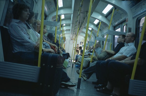 20059179 ENGLAND  London The London Underground. Interior view through the train carriage with passengers sitting on seats.