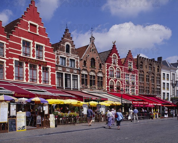 BELGIUM, West Flanders, Bruges, Line of cafes and restaurants with colourful awnings in Bruges market place