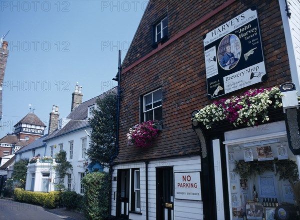 20059216 ENGLAND East Sussex Lewes John Harvey Brewery sign on the side of The Brewery Shop Wall in Cliff High Street with the brewery yard further down the road in the distance.