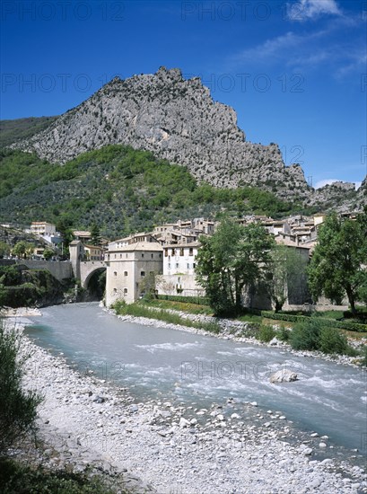 FRANCE, Provence Cote d Azur, Alpes de Haute Provence, Entrevaux. View along the river Var toward the medieval village and rocky cliff above