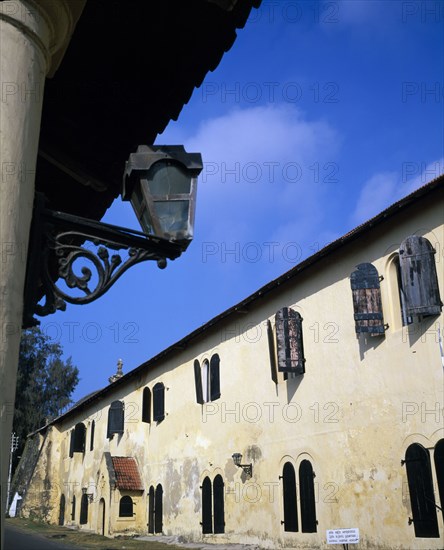 SRI LANKA, Galle, National Maritime Museum. Old fort building with multiple wooden shuttered windows and old style lantern detail in the foreground