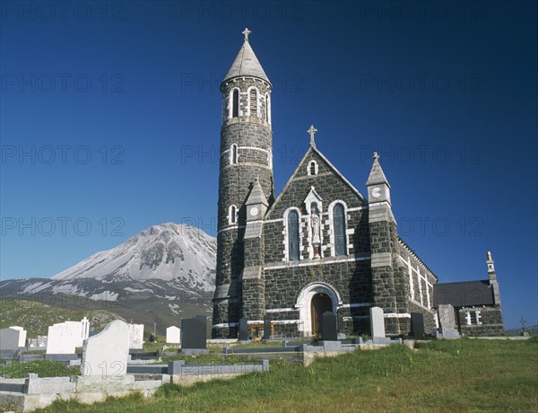 IRELAND, County Donegal, Dunlewy Village, Roman Catholic church and graveyard with Errigal peak of the Derryveagh Mountain Range behind