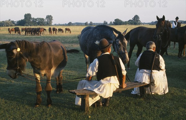 HUNGARY, Great Hungarian Plain, Bugac Csarda, Dismounted cossack horseman with pair of horses and donkey.