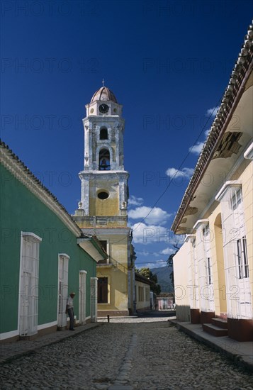 CUBA, Sierra de Trinidad, Trinidad, View along street of colourful colonial architecture toward church bell tower