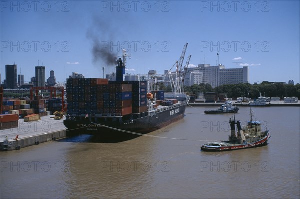 ARGENTINA, Buenos Aires, Tugboat and container ship in dock.