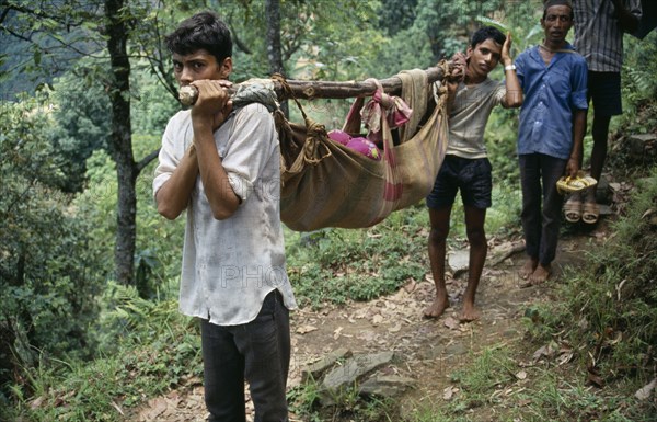 NEPAL, Health, Patient being carried in cloth stretcher.