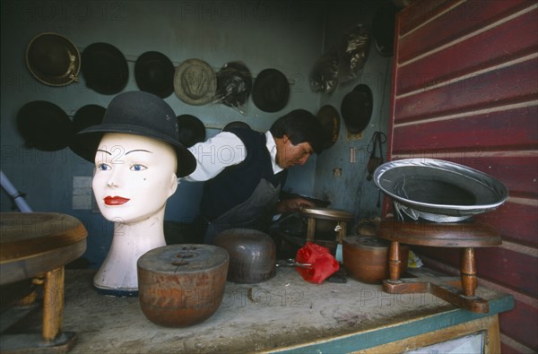 BOLIVIA, La Paz, El Alto, Hat maker in La Ceja making traditional brown and grey bowler hats known locally as a bombin.