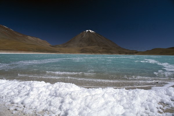 BOLIVIA, Altiplano, Potosi, "Salar de Uyuni, Laguna Verde.  Salt crusted shore and jade coloured water."