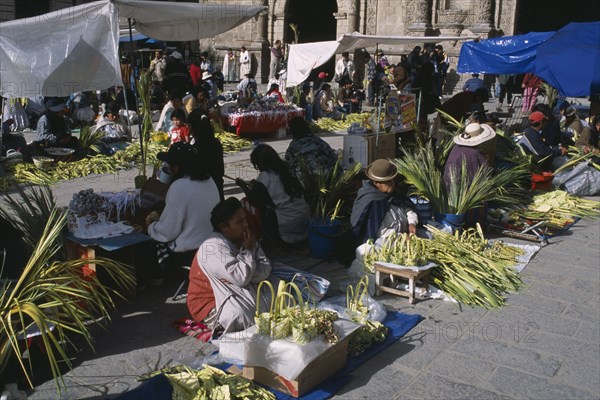 BOLIVIA, La Paz, Women selling woven palm baskets and palm fronds outside San Francisco church for Palm Sunday.