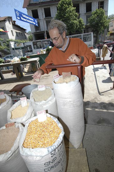 ROMANIA, Tulcea, Tulcea, Buyer checking sacks of lentils pulses rice and wheat at the fresh produce market