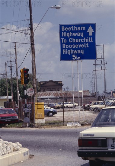 WEST INDIES, Trinidad, Port of Spain, Road scene with large blue and white highway sign.