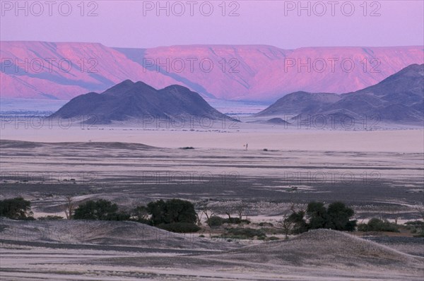 NAMIBIA, Namib Desert, Desert mountains and plains with pink and purple sky overhead