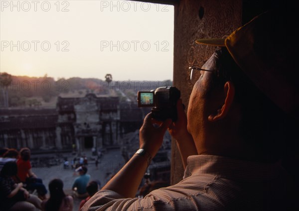 CAMBODIA, Siem Reap Province, Angkor Wat, Tourist with video camera.