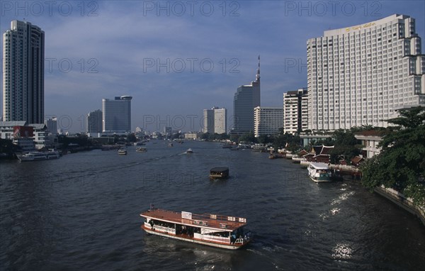 THAILAND, South, Bangkok, The Shangri La Hotel on the right The Peninsula Hotel on the left either side of the Chao Phraya river with a cross river ferry in the foreground