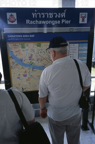 THAILAND, South, Bangkok, Tourist at Rachawongse Pier looking at a map of Chinatown