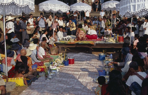 CAMBODIA, Siem Reap, Angkor Wat, Shaman ceremony watched by Khmer people and tourists with food offerings laid out on the ground