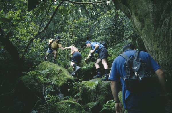 SEYCHELLES, Mahe Island, Local guide Basil Beaudouin leading tourists on Congo Rouge Trail.