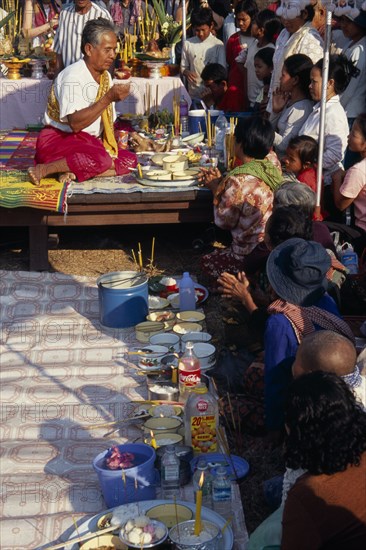 CAMBODIA, Siem Reap, Angkor Wat, Shaman at ceremony smelling the offerings of food brought by the Khmer people