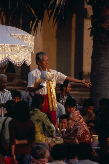 CAMBODIA, Siem Reap, Angkor Wat, Shaman at ceremony blessing devotees with the holy water