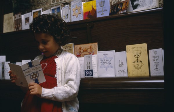 ENGLAND, Religion, Judaism, Little girl looking at greetings cards for Jewish New Year.