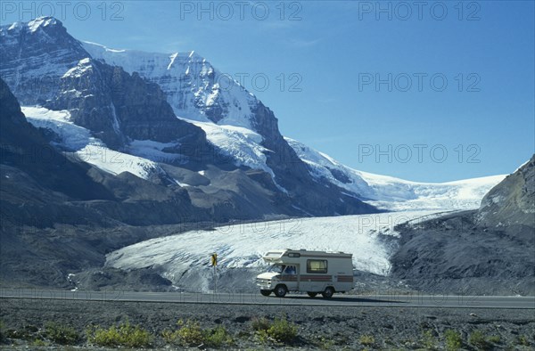 CANADA, British Columbia, Jasper National Park, Canadian Rocky Mountains.  A holiday van on the Icefield Parkway passing the Athabasca Glacier.