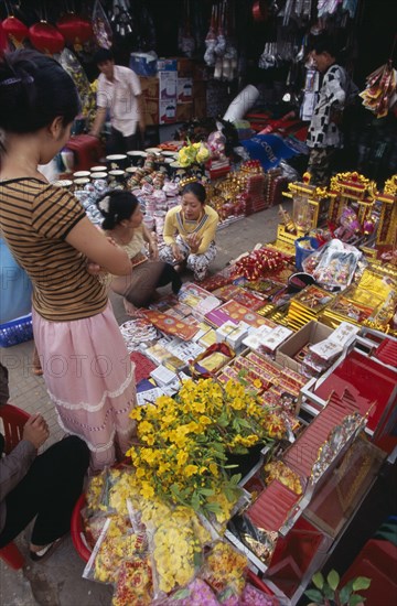 CAMBODIA, Siem Reap, Display of various religious goods for sale in the old market during Chinese New Year with customers buying goods