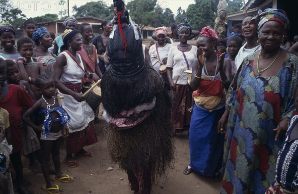 SIERRA LEONE, Kambla, Female initiation ceremony with masked initiate amongst a group of women and children