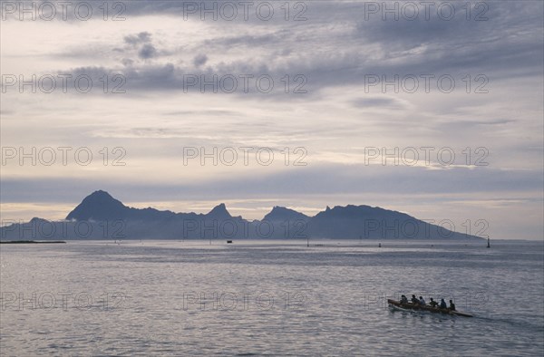 PACIFIC ISLANDS, French Polynesia, Tuamotu Islands, Ringiroa.  Kayak on water in low light with silhouetted island coastline.