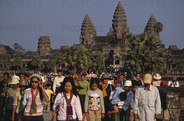 CAMBODIA, Siem Reap Province, Angkor Wat, Tourists on stone causeway leading to temple complex.  Many Cambodians visiting during Chinese New Year.