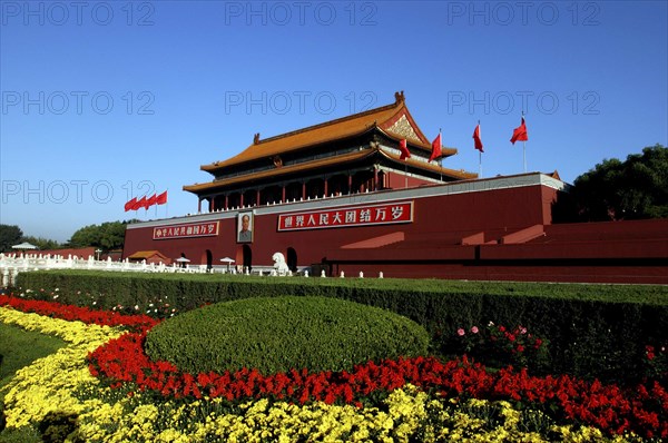 CHINA, Beijing, Tiananmen Square, Tiananmen Monument aka Gate of Heavenly Peace with portrait of Mao on the front and flower beds in the foreground