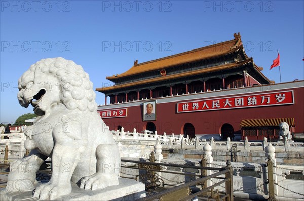 CHINA, Beijing, Tiananmen Monument aka Gate of Heavenly Peace with portrait of Mao on the front and stone lion statue in the foreground