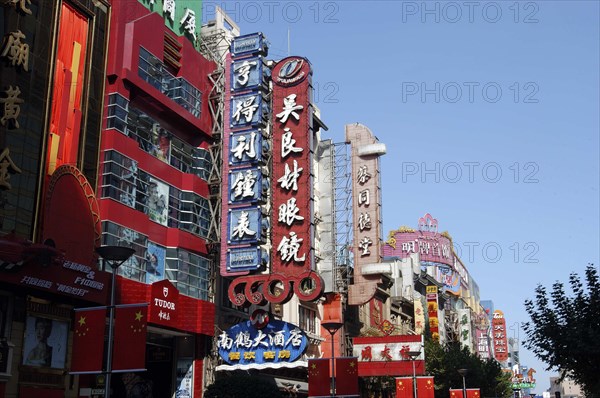 CHINA, Shanghai, Street scene with building facades cluttered with signs