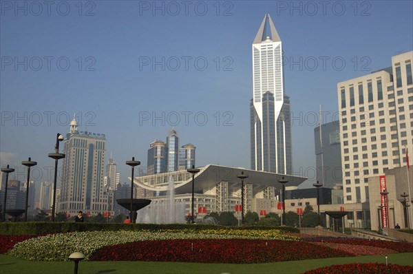 CHINA, Shanghai, Modern city skyline seen over formal garden in the foreground