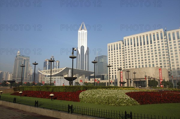 CHINA, Shanghai, Modern city skyline seen over formal garden in the foreground