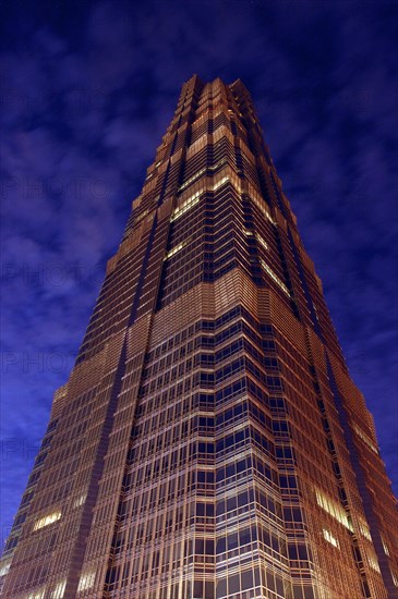 CHINA, Shanghai, Angled view looking up at the Hyatt Hotel skyscraper illuminated at dusk