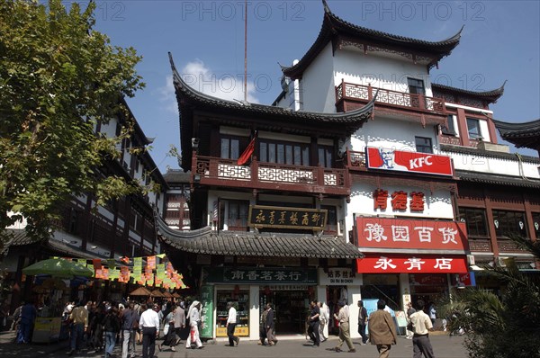 CHINA, Shanghai, Yuyuan Gardens. Three tiered traditional style building with shops and KFC fast food Restaurant on the ground floor
