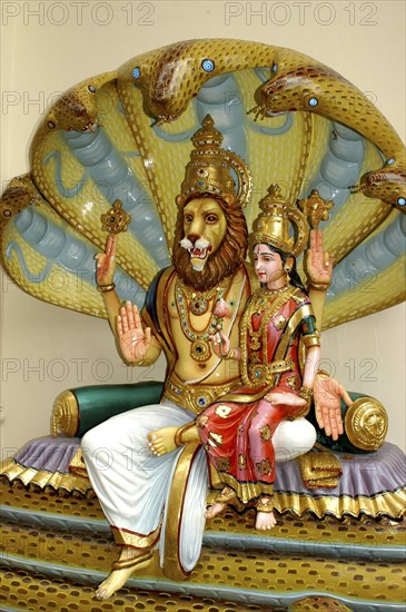 SINGAPORE, , Colurful statue of a lion headed God with four arms and a female figure sitting on his lap at an Indian Hindu Temple