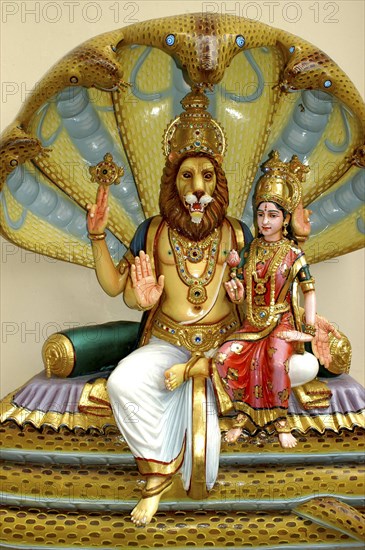 SINGAPORE, , Colurful statue of a lion headed God with four arms and a female figure sitting on his lap at an Indian Hindu Temple