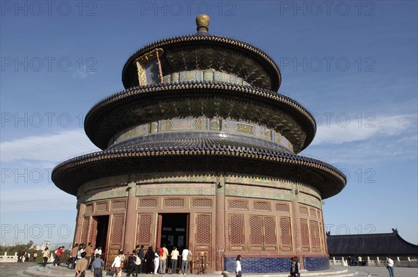 CHINA, Beijing, Tiantan Park, aka The Temple of Heaven. View of the Hall of Prayer for Good Harvests with people gathered at the base