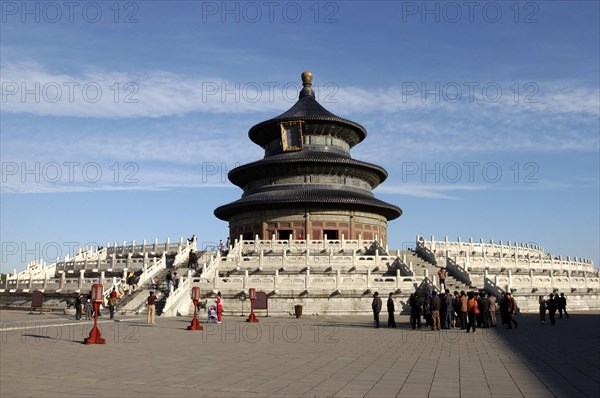 CHINA, Beijing, Tiantan Park, aka The Temple of Heaven. View of the Hall of Prayer for Good Harvests with people gathered at the base of the steps