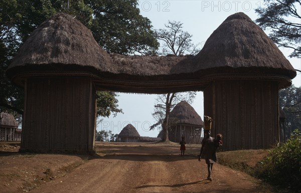 CAMEROON, Bafut, Thatched gateway with woman and children below.