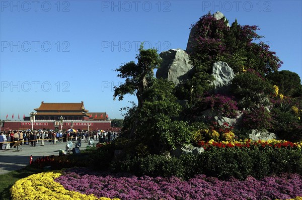 CHINA, Beijing, Tiananmen Square, Gate of Heavenly Peace or Tiananmen. View over rockery and flowerbeds toward crowds gathered outside the gate building