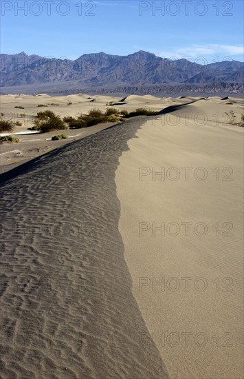 USA, California, Death Valley, View along the ridge of a sand dune in the desert landscape with a rocky horizon in the distance