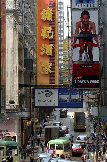 HONG KONG, General, View along city street with passing traffic and large advertising banners overhead