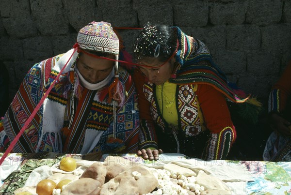 PERU, Cordillera Vilcanota, Bride and groom during their wedding ceremony with length of red textile encircling their heads.