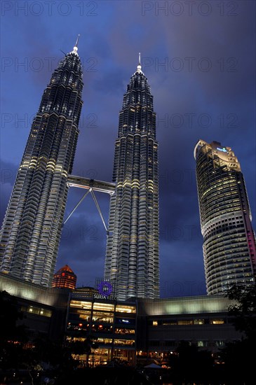 MALAYSIA, Kuala Lumpur, Angled view looking up at the Petronas Twin Towers illuminated at night