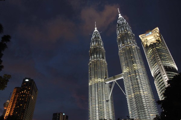 MALAYSIA, Kuala Lumpur, Angled view looking up at the Petronas Twin Towers illuminated at night