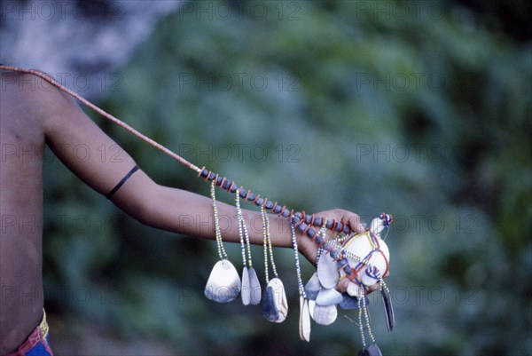 PAPUA NEW GUINEA, Trobriand Islands, Cropped shot of extended arm displaying kula necklace.